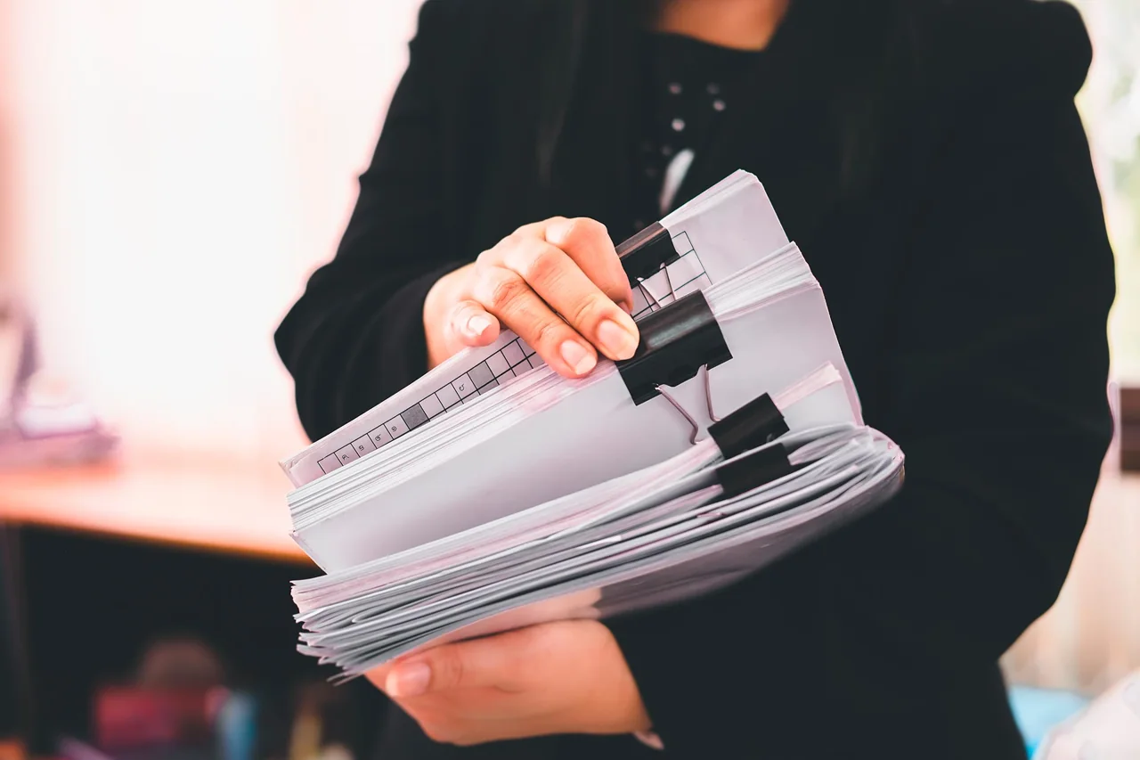 Profissional organizando um conjunto de documentos em papel